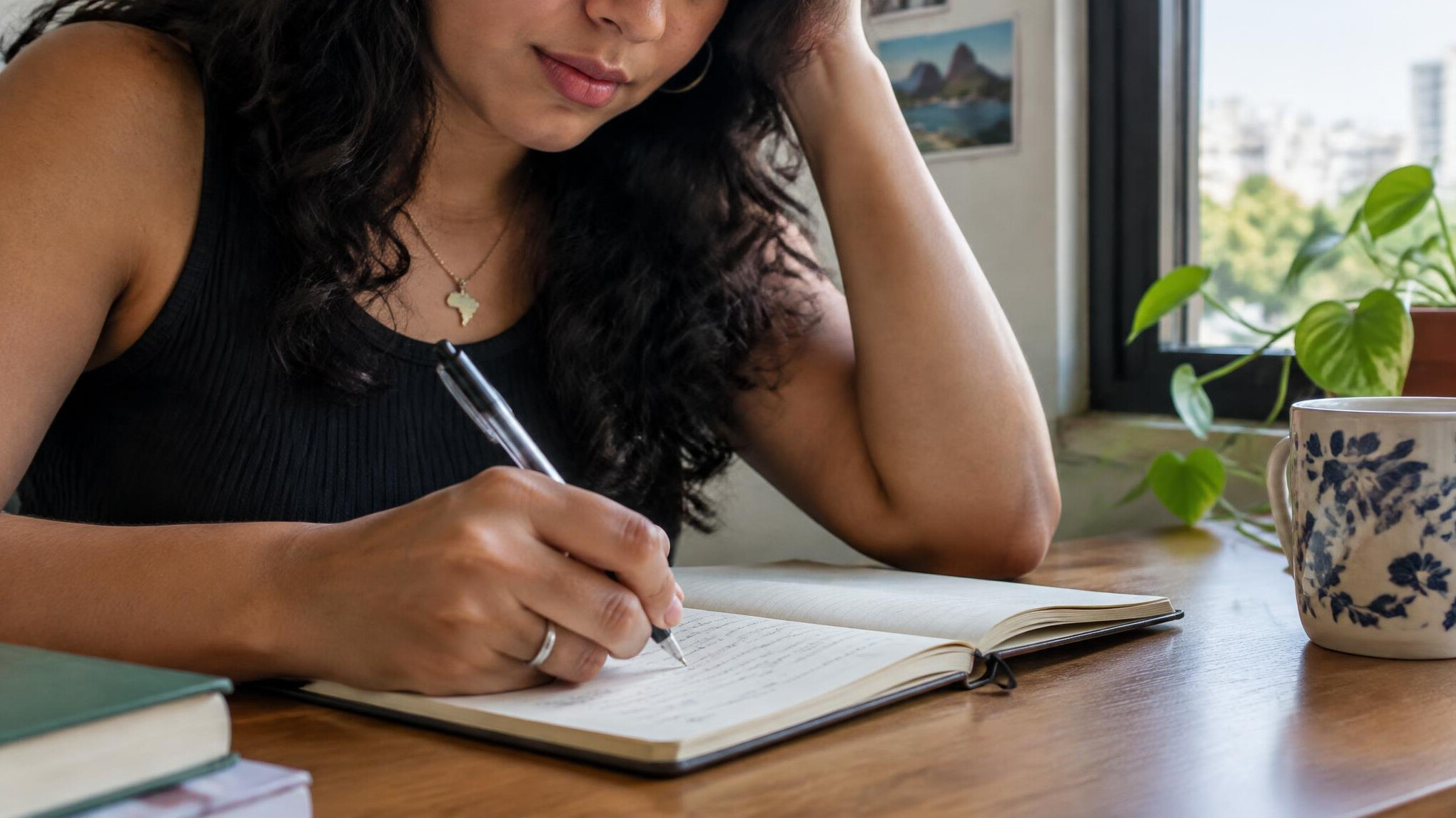 Person writing in a journal at a desk